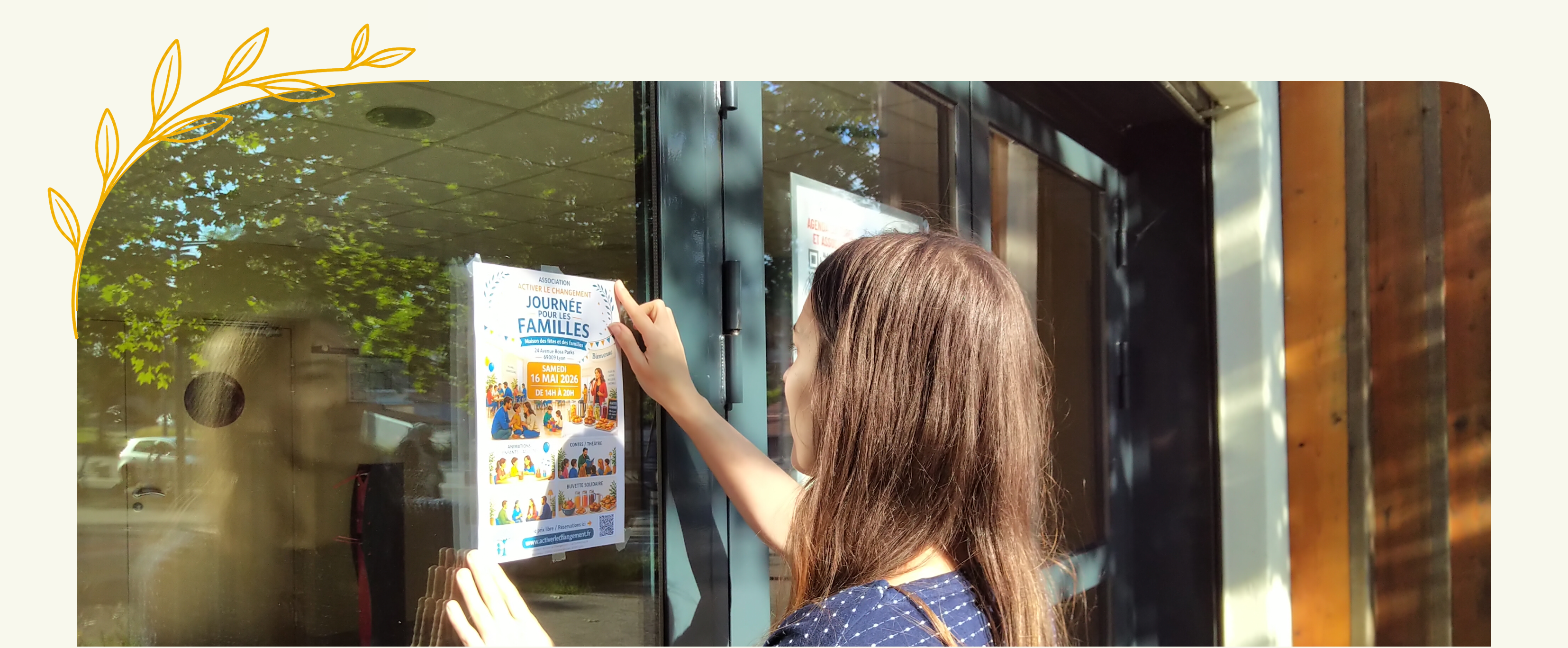 Une bénévole installe l’affiche de la Journée pour les familles sur une vitre.